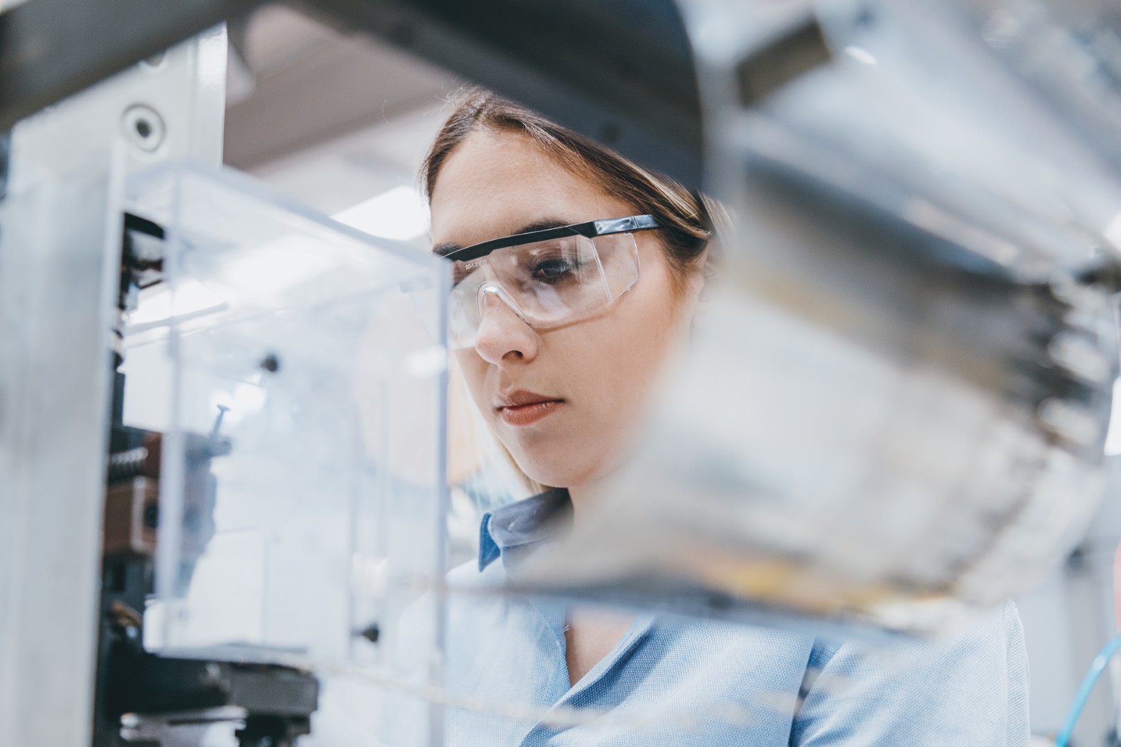 Female industrial worker working with manufacturing equipment in a factory
