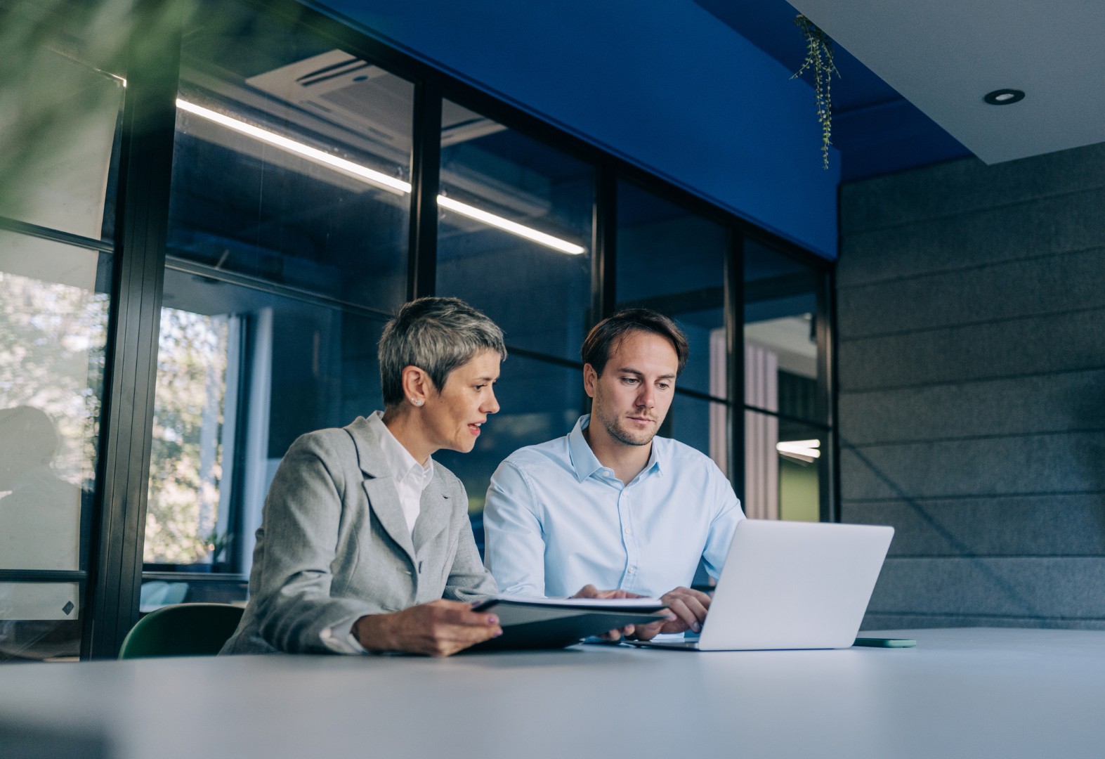 Shot of two confident business persons on meeting in the office. Shot of businessman and businesswoman in meeting at the office. Business couple discussing important documentation in the workplace. Two business people in office working on Gender Pay Gap Reporting